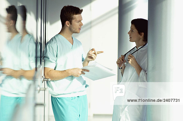 Seitenprofil von zwei Ärzten  die eine Krankenakte besprechen