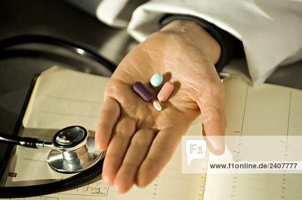 Nahaufnahme von Pillen auf der Handfläche eines Arztes