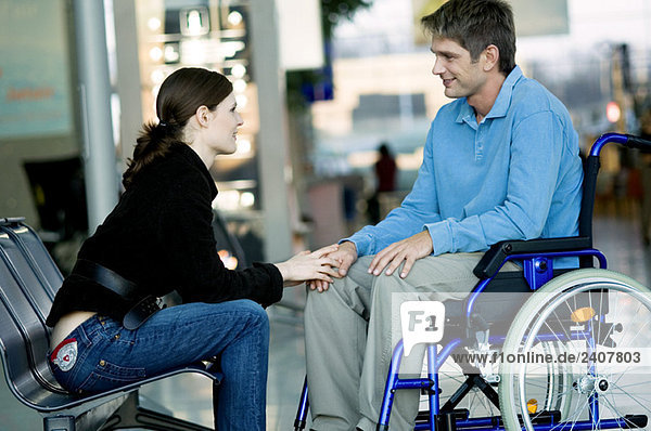 Seitenprofil einer jungen Frau im Gespräch mit einem mittelgroßen Mann