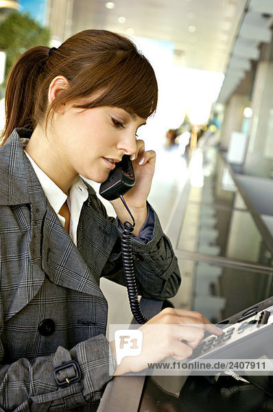 Geschäftsfrau beim Telefonieren am Flughafen