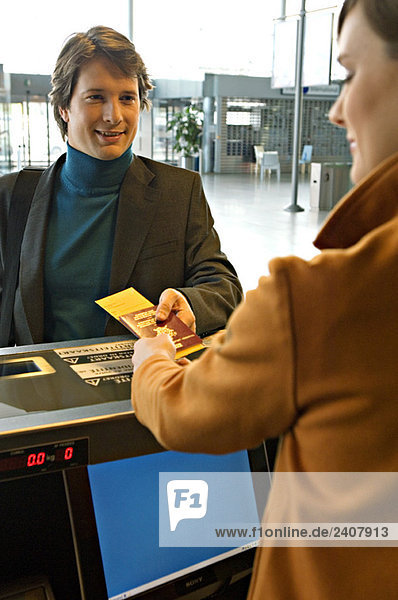 Businessman with a female check-in attendant at an airport check-in counter