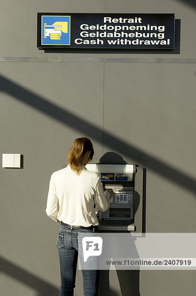 Rear view of a businesswoman using an ATM