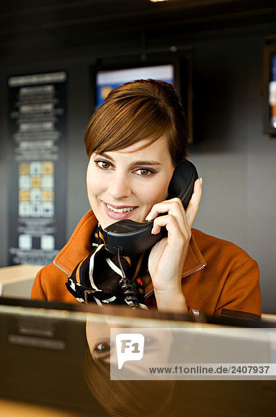 Portrait of an airline check-in attendant talking on the telephone