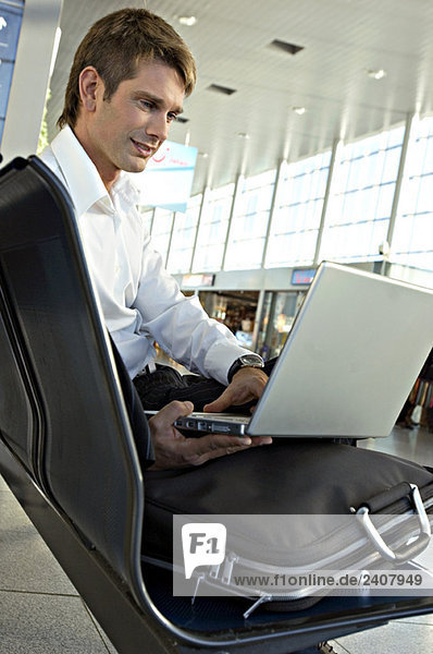 Businessman using a laptop at an airport lounge