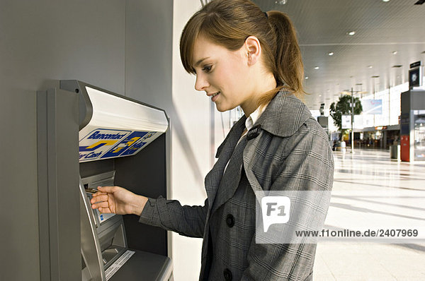 Seitenansicht einer Geschäftsfrau mit einem Geldautomaten