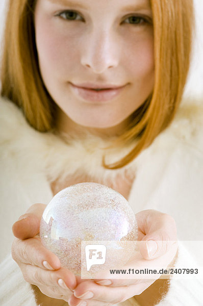 Porträt einer jungen Frau mit einer Kristallkugel