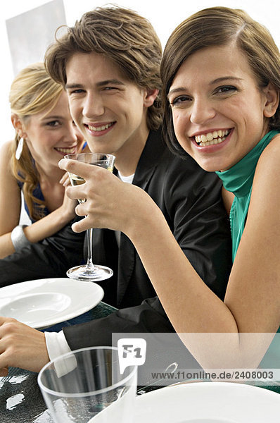 Zwei junge Frauen mit einem Teenager auf einer Dinnerparty