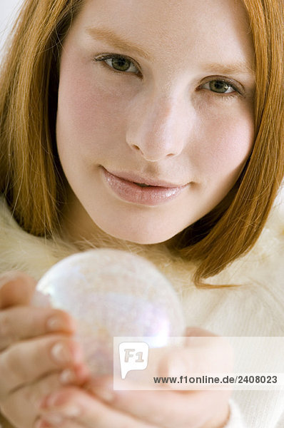 Portrait of a young woman holding a crystal ball