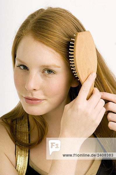 Porträt einer jungen Frau beim Haareputzen