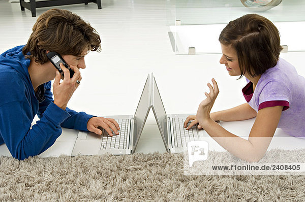 Teenager-Junge und eine junge Frau mit Laptops