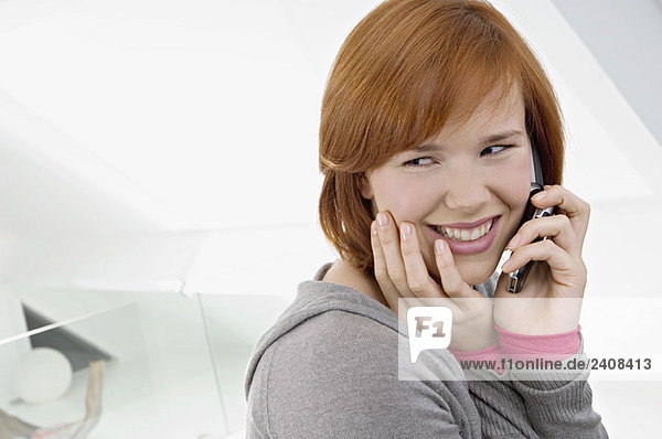 Seitenprofil einer jungen Frau mit Handy und lächelndem Gesicht
