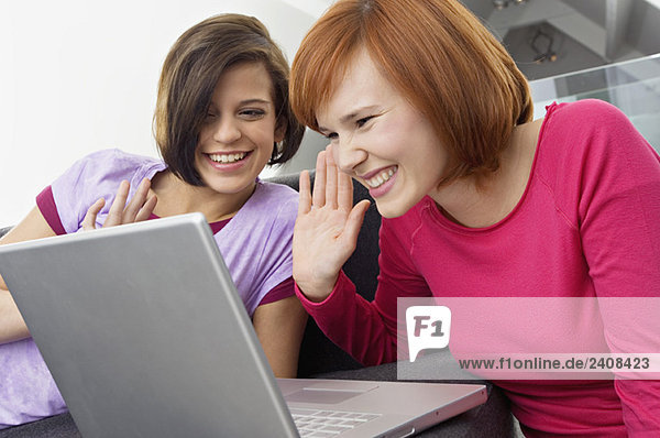 Two young women using a laptop