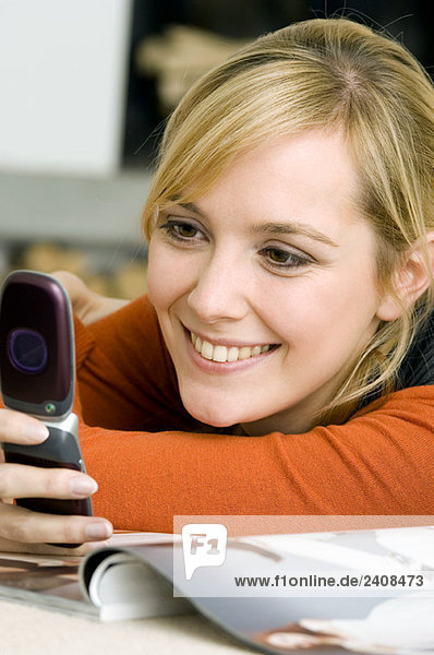 Nahaufnahme einer jungen Frau mit dem Handy und lächelndem Gesicht