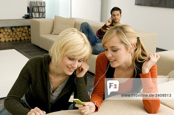 Two young women listening to an MP3 player