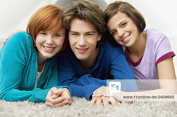 Porträt eines Teenagers  der mit zwei jungen Frauen lächelt