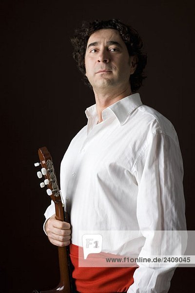 Stereotypischer spanischer Mann in traditioneller Kleidung mit Akustikgitarre