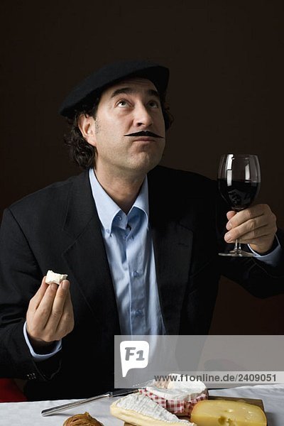 Stereotypischer Franzose mit französischem Käse und einem Glas Rotwein