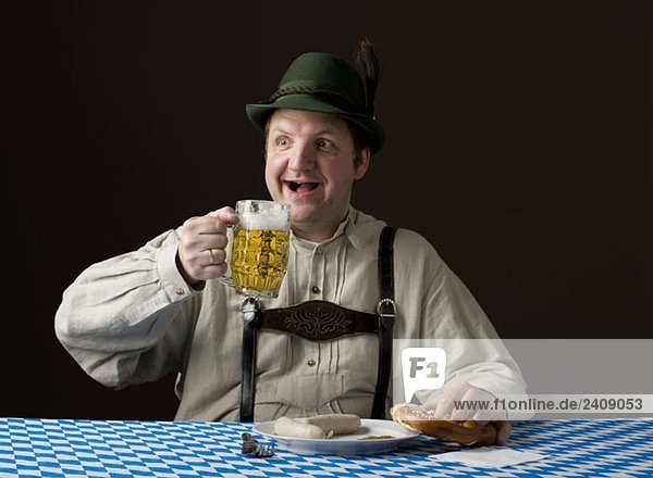 Stereotypischer deutscher Mann mit Bier und Brezel