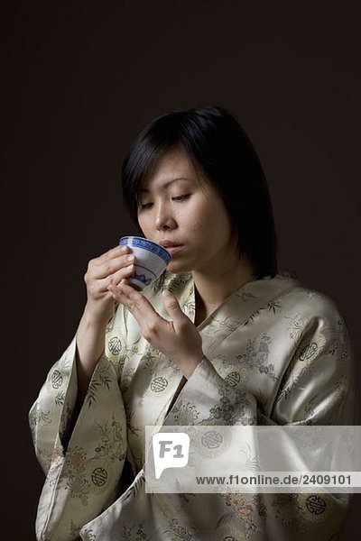 Eine Frau im Kimono beim Tee trinken
