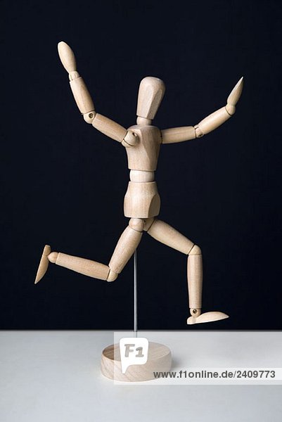 Künstlerfigur mit erhobenen Armen laufend