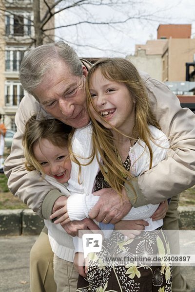 Großvater umarmt seine Enkelkinder