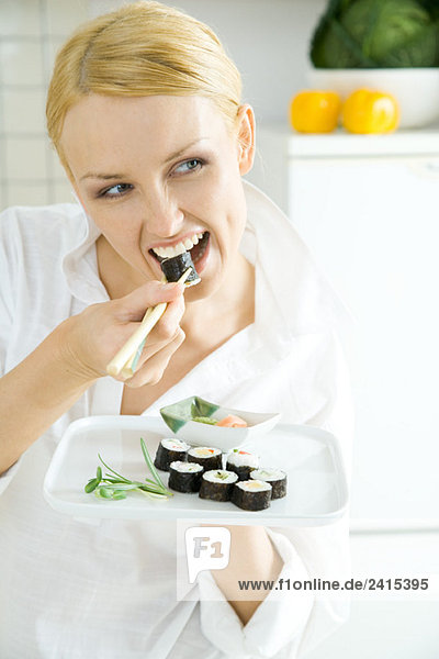 Junge Frau isst Sushi