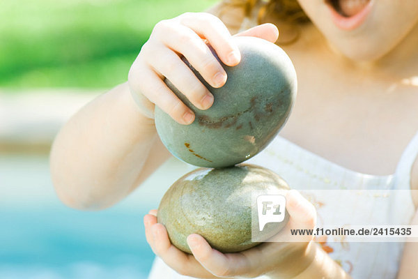 Kind spielt mit Steinen
