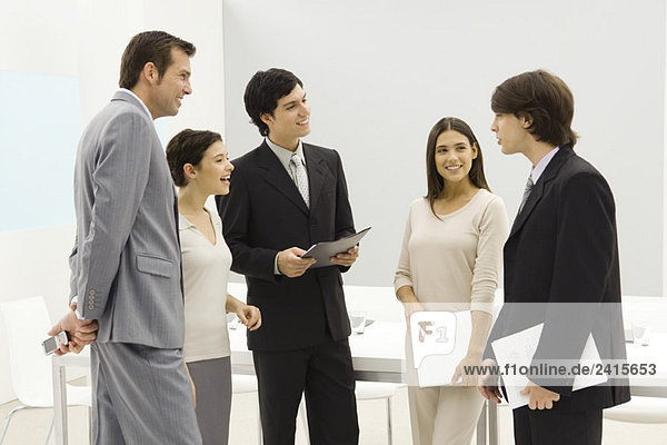 Group of business associates standing together  smiling  chatting