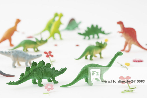 Plastikdinosaurier umgeben von gefälschten Blumen