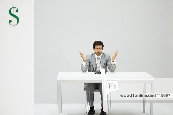 Mann am Schreibtisch sitzend mit Addiermaschine  aufgeblasenen Wangen  erhobenen Händen