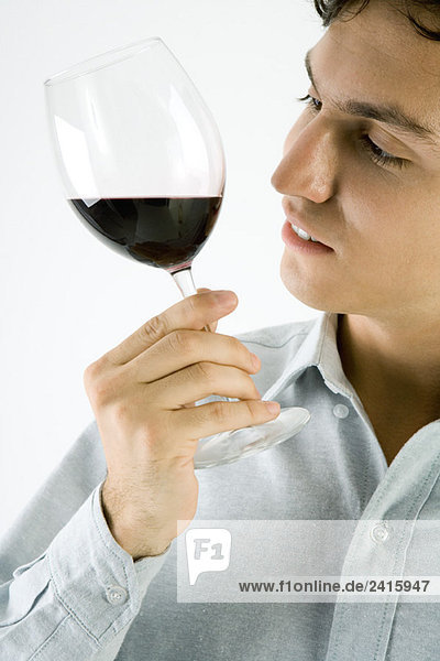 Mann studiert ein Glas Rotwein  Nahaufnahme
