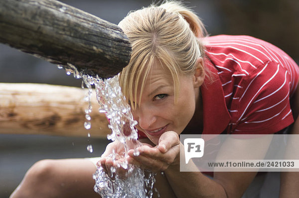 Blonde Frau trinkt Wasser  Porträt
