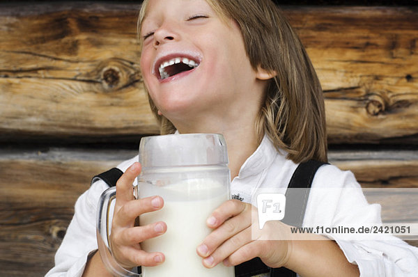 Österreich  Salzburger Land Junge (8-9) trinkt Milch  lacht  Portrait