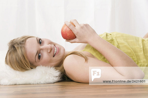 Blonde Frau hält einen Apfel  Portrait