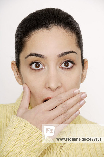 Young woman covering mouth with hand