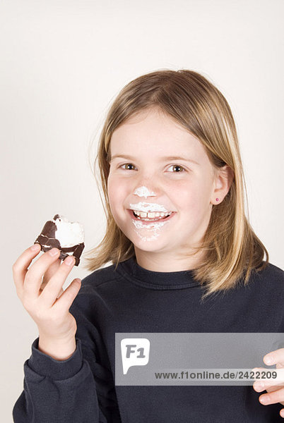 Blondes Mädchen (8-9) mit einem Schoko-Marshmallow  Portrait