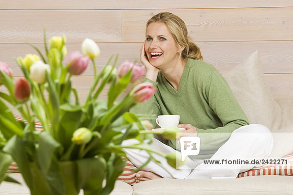 Junge Frau hält Tasse Kaffee  lächelnd  Portrait