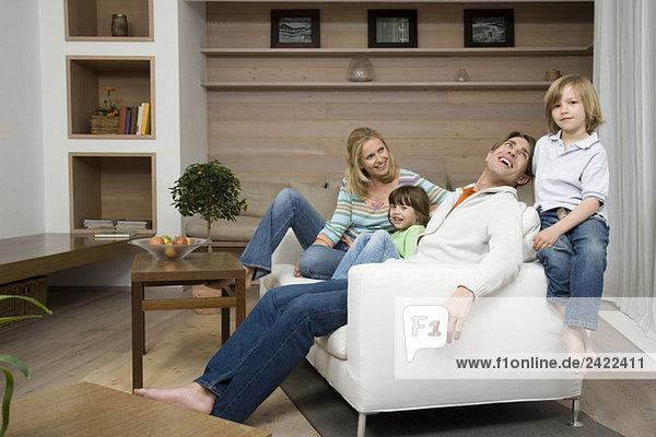 Familie auf Sofa sitzend  lächelnd  Portrait