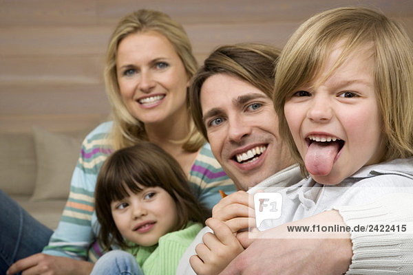 Familienporträt  Junge (8-9)  Zunge herausstreckend  lächelnd