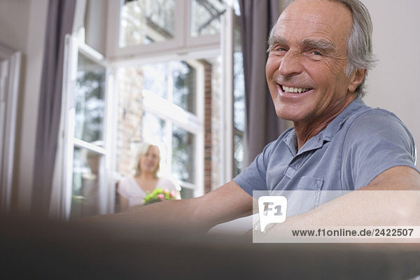 Älterer Mann am Tisch sitzend  lächelnd  Porträt