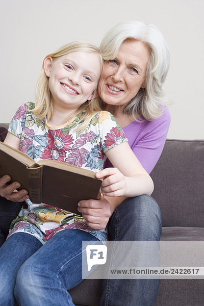 Großmutter und Großmutter (8-9) Lesebuch auf Sofa  Portrait