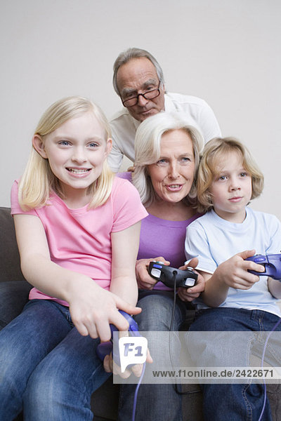 Großeltern und Enkel (8-9) spielen Videospiel  Portrait