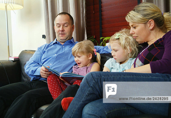 Family reading together in sofa