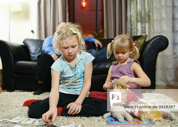 Two girls sitting on the floor playing