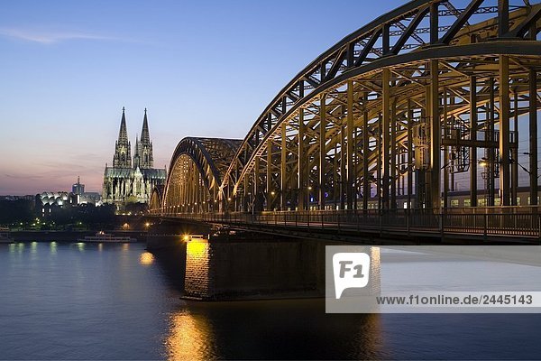 Brücke und Kirche beleuchtet in der Dämmerung  Hohenzollernbrücke  Kölner Dom Köln  Rhineland  Nordrhein-Westfalen  Deutschland