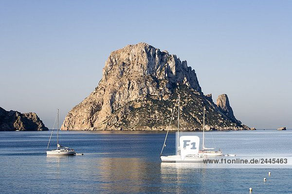 Segelboote im Meer mit Felsformation im Hintergrund  Es Vedra  Cala d ' Hort  Ibiza  Balearen Inseln  Spanien