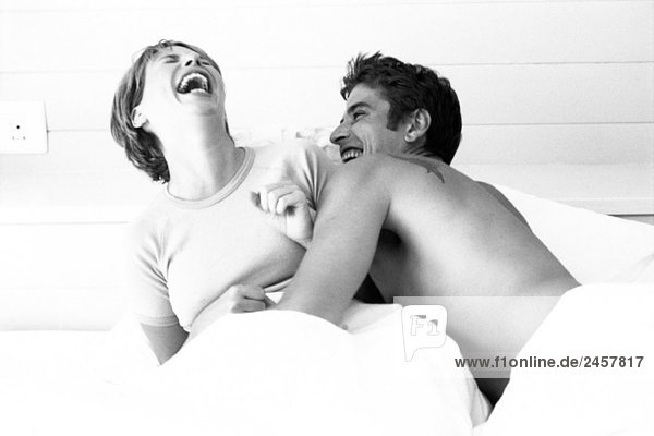 Paar im Bett  beide lachend