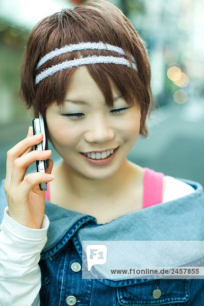 Junge Japanerin mit Handy  lächelnd