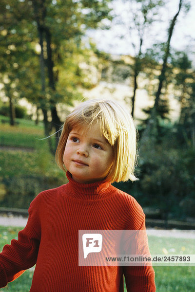 Little girl outdoors  wearing turtleneck  looking away  portrait