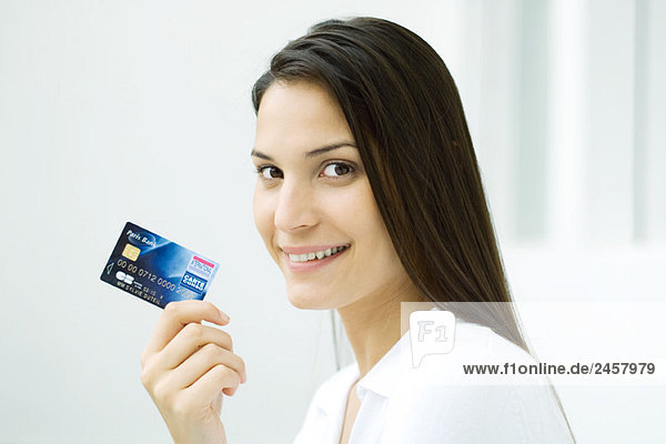 Frau mit Kreditkarte  lächelnd vor der Kamera